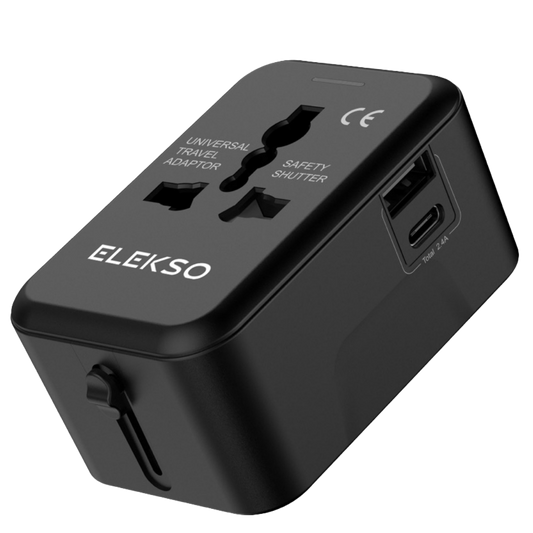 Zwarte ELEKSO universele reisstekker met USB-C en USB-A poort, schuin gefotografeerd met zicht op alle invoerpoorten en safety shutter-systeem.