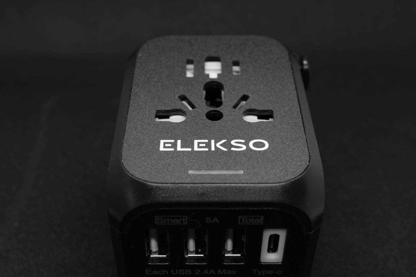 Bovenaanzicht van de ELEKSO universele reisstekker met meerdere internationale invoerpoorten en vier USB-uitgangen, inclusief USB-C.