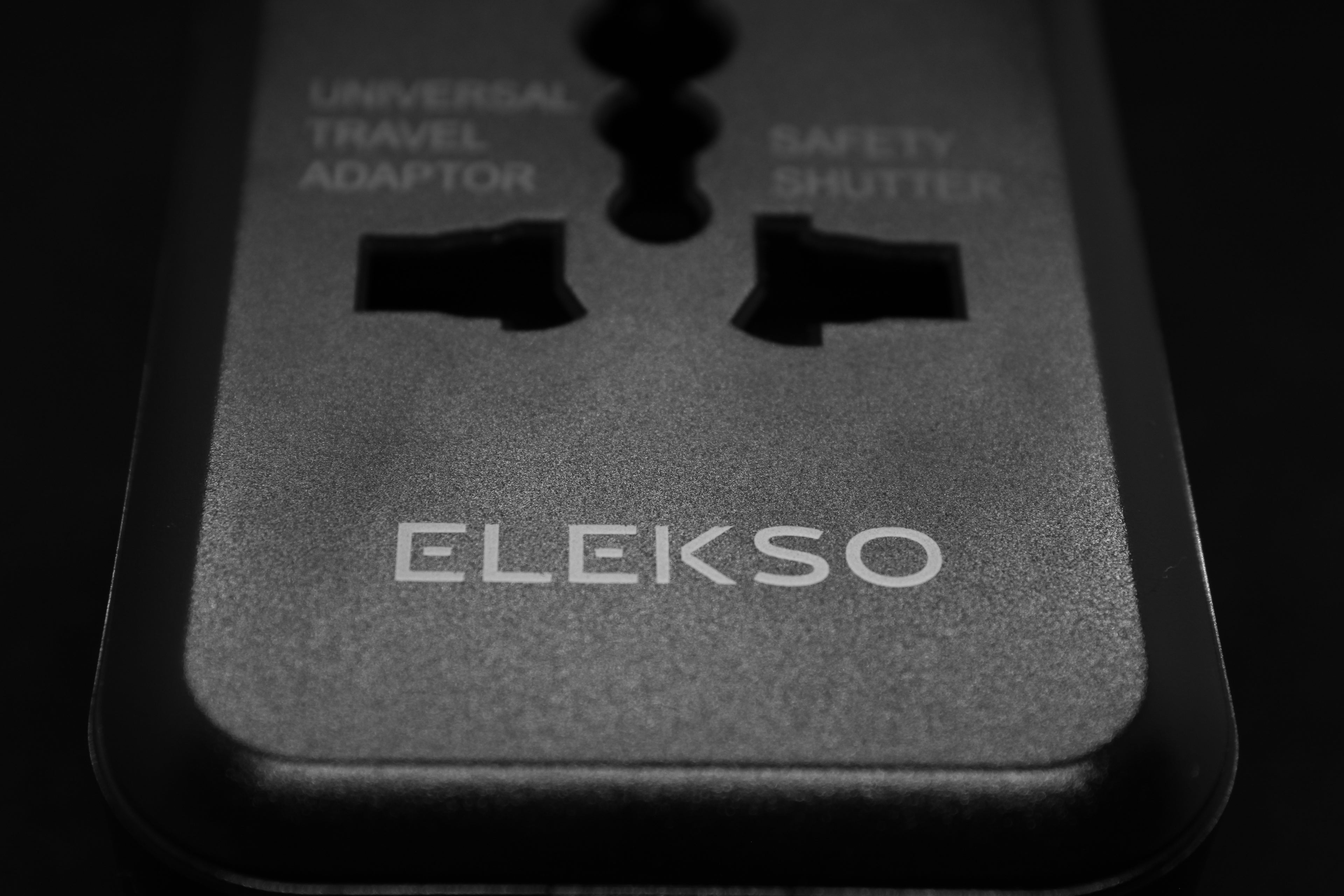 Bovenaanzicht van de ELEKSO universele reisadapter met safety shutter en logo, geschikt voor stopcontacttypes wereldwijd.