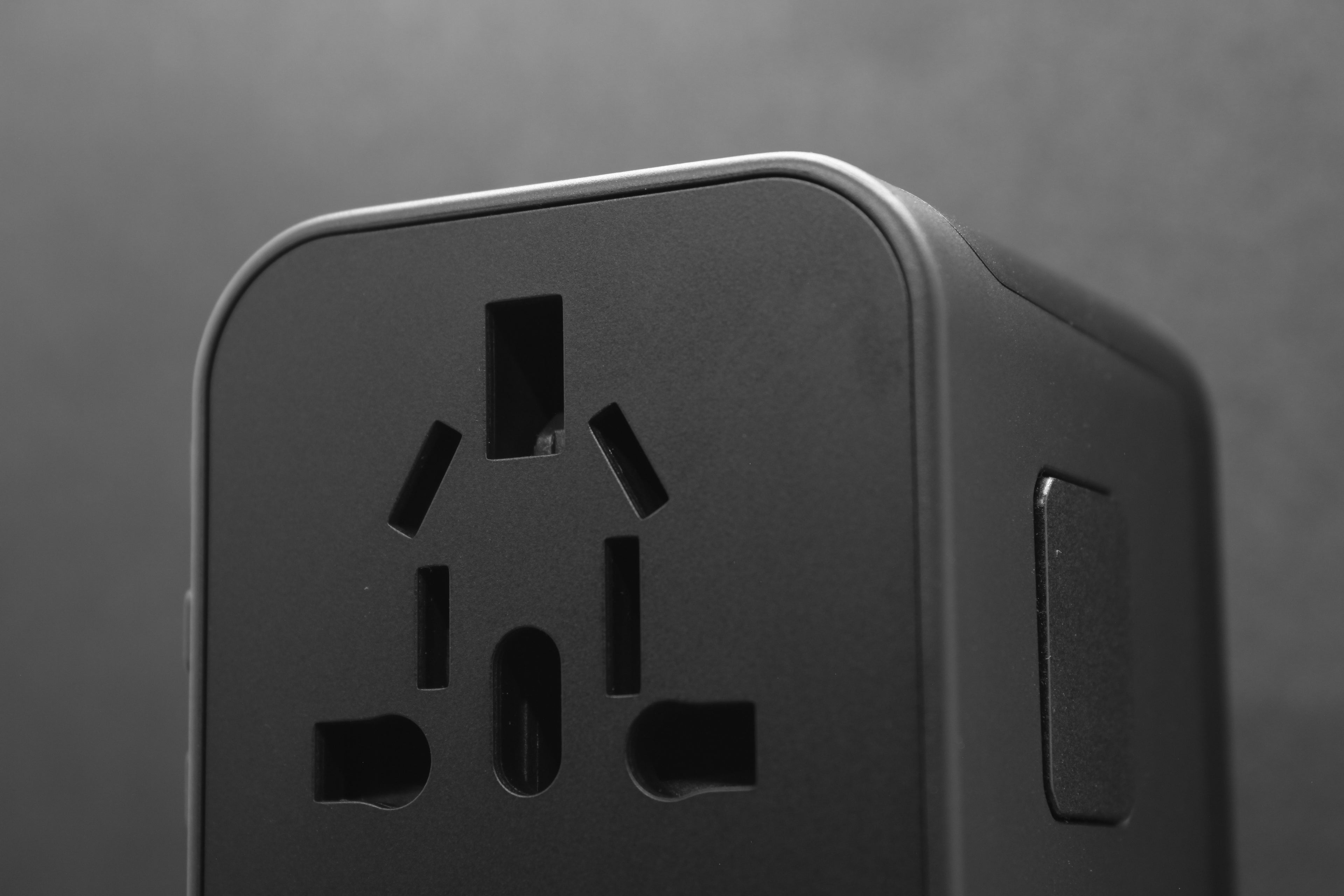 Close-up van de internationale stekkeropeningen op de voorkant van de ELEKSO universele adapter.