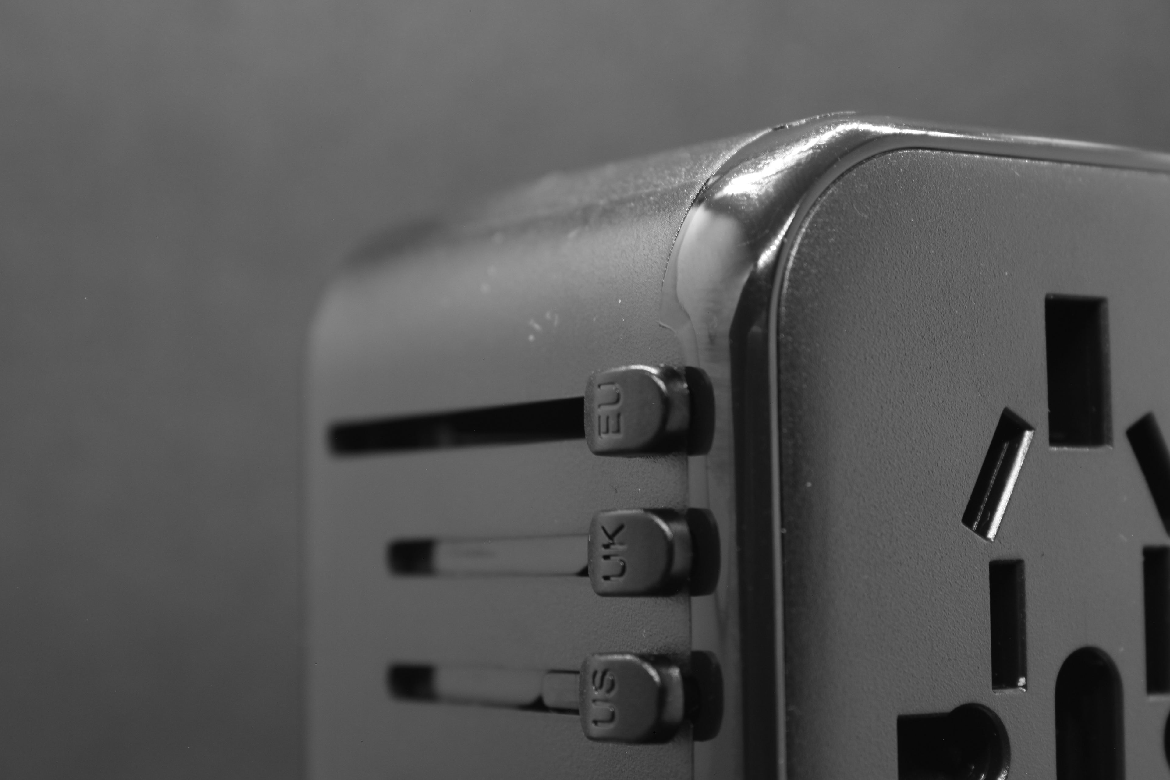 Zijaanzicht van de ELEKSO wereldstekker met zichtbaar schuifmechaniek en afgeronde designvorm.